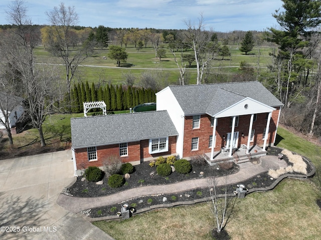987 Grooms Rd, Rexford, NY 12148 - neoclassical / greek revival house featuring a porch, roof with shingles, concrete driveway, and brick siding