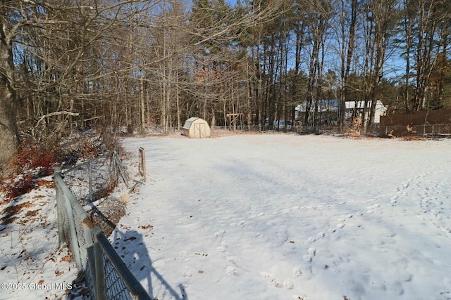 yard covered in snow with a storage unit