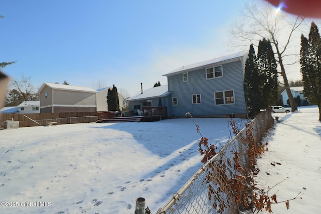 view of snow covered back of property