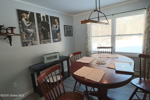 dining space featuring a baseboard heating unit, crown molding, and hardwood / wood-style flooring