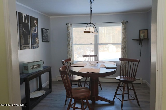 dining area featuring hardwood / wood-style flooring, baseboard heating, and crown molding