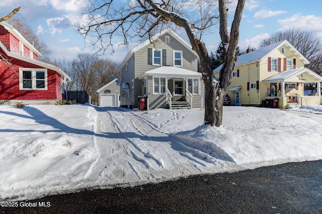 view of front of home featuring covered porch, a garage, and an outbuilding