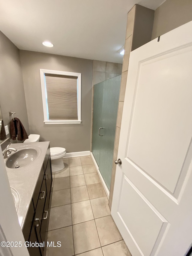 bathroom with tile patterned flooring, vanity, toilet, and a shower with shower door