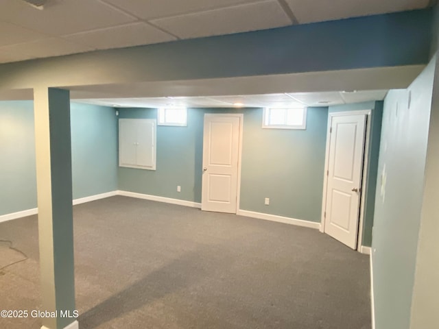 basement with a paneled ceiling and carpet flooring