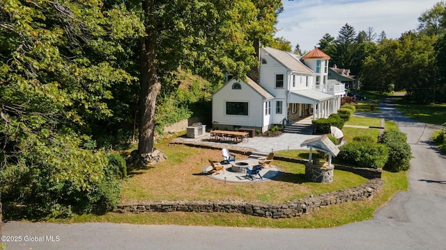 view of front of house featuring a patio, a front yard, and a fire pit