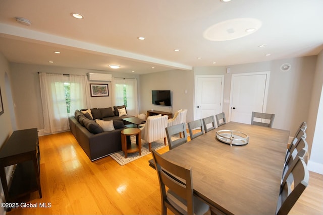 dining space featuring a wall mounted AC and light hardwood / wood-style flooring