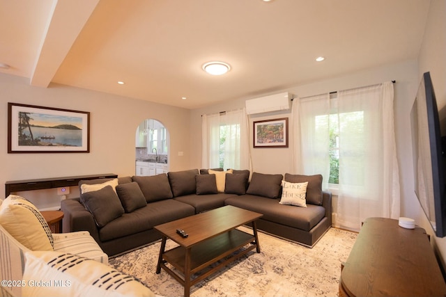 living room featuring sink, a wall mounted air conditioner, and beam ceiling