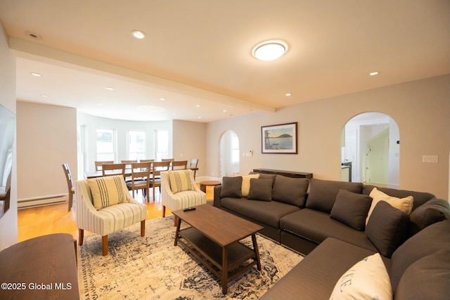 living room featuring beam ceiling, light wood-type flooring, and baseboard heating