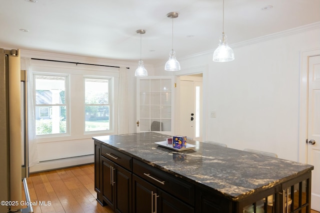 kitchen with pendant lighting, a baseboard radiator, dark stone countertops, ornamental molding, and a center island