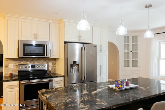 kitchen with stainless steel appliances, a center island, pendant lighting, and decorative backsplash