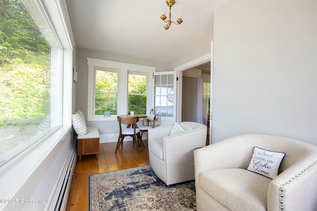 sunroom featuring plenty of natural light, a chandelier, and a baseboard radiator