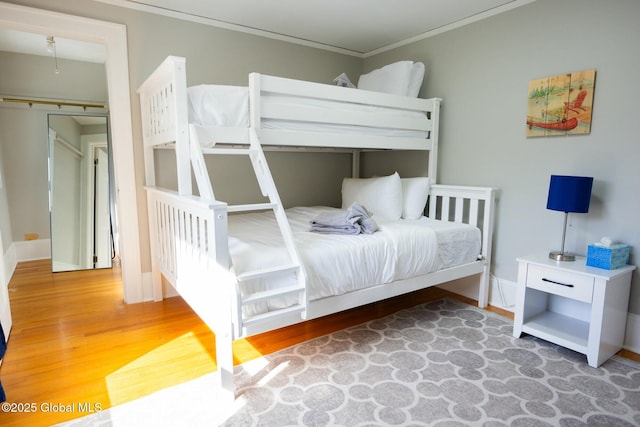 bedroom with crown molding, hardwood / wood-style floors, and a closet