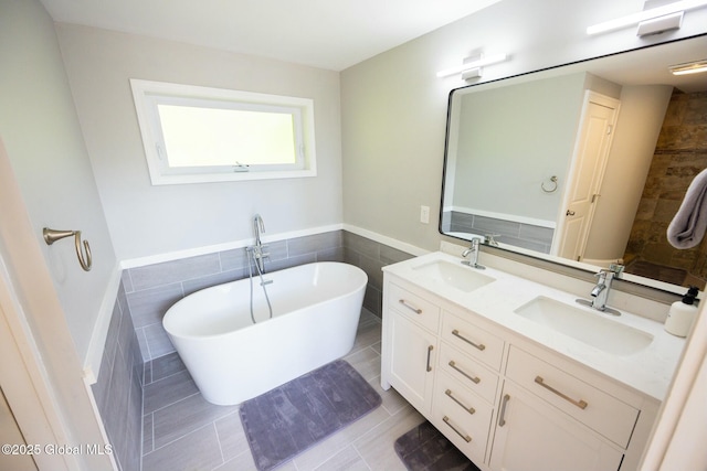 bathroom featuring a washtub, vanity, tile patterned floors, and tile walls