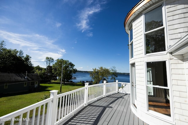 wooden deck with a water view and a yard