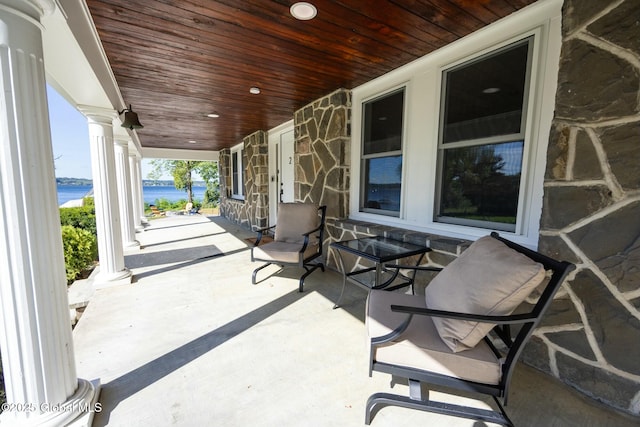 view of patio with a porch and a water view