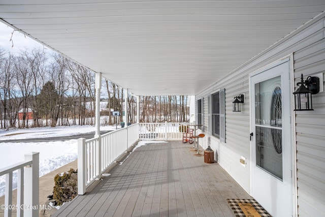 snow covered deck with covered porch