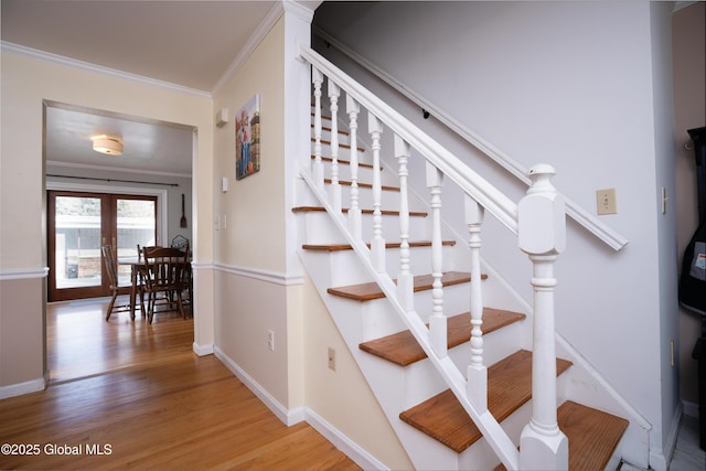 stairs featuring french doors, ornamental molding, and hardwood / wood-style floors