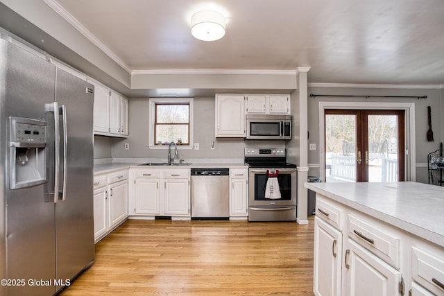 kitchen with sink, a wealth of natural light, white cabinets, and appliances with stainless steel finishes