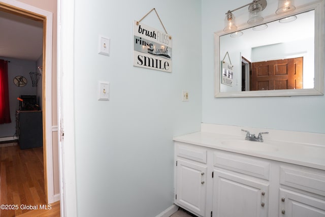 bathroom featuring hardwood / wood-style flooring, vanity, and baseboard heating