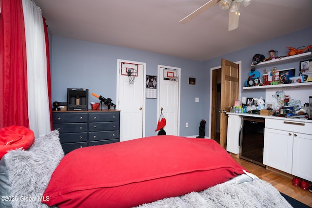 bedroom featuring wine cooler, ceiling fan, and light wood-type flooring