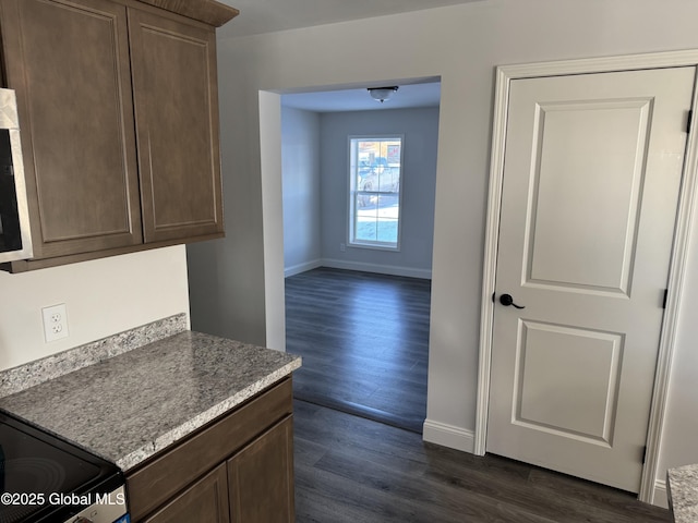 kitchen featuring dark wood-type flooring and dark brown cabinetry