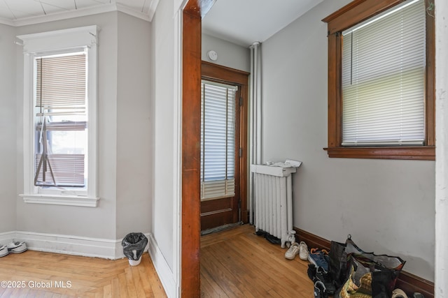 interior space featuring crown molding, wood-type flooring, and radiator heating unit