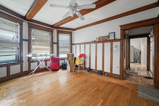 miscellaneous room with ceiling fan, ornamental molding, beam ceiling, and light wood-type flooring