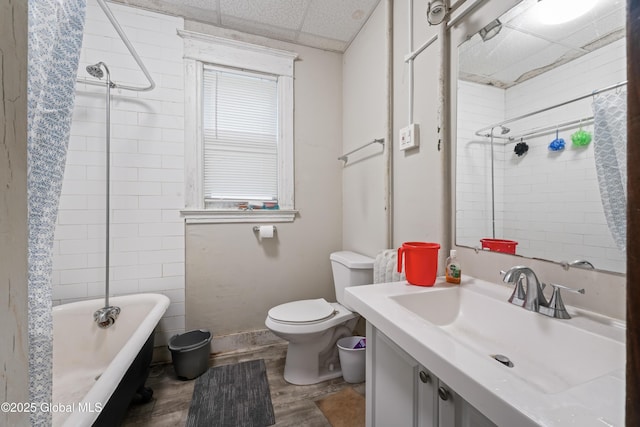 full bathroom with sink, hardwood / wood-style flooring, a paneled ceiling, bathing tub / shower combination, and toilet