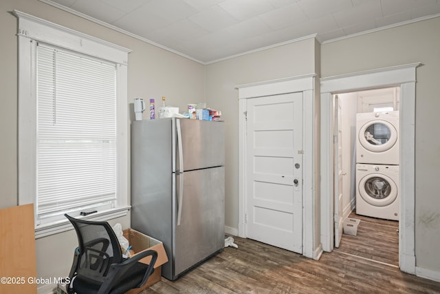 kitchen featuring ornamental molding, stacked washer / drying machine, and stainless steel refrigerator