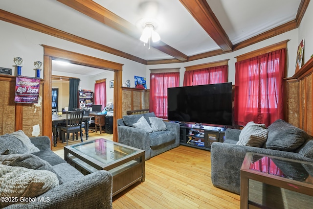 living room featuring beamed ceiling, ornamental molding, ceiling fan, and light hardwood / wood-style flooring