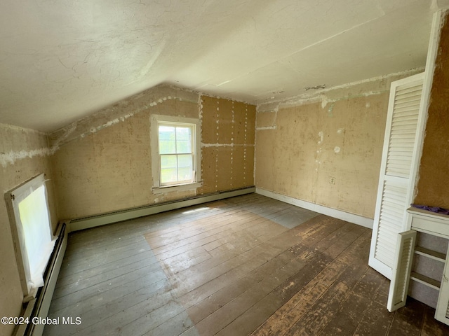 additional living space featuring baseboard heating, dark hardwood / wood-style floors, and lofted ceiling