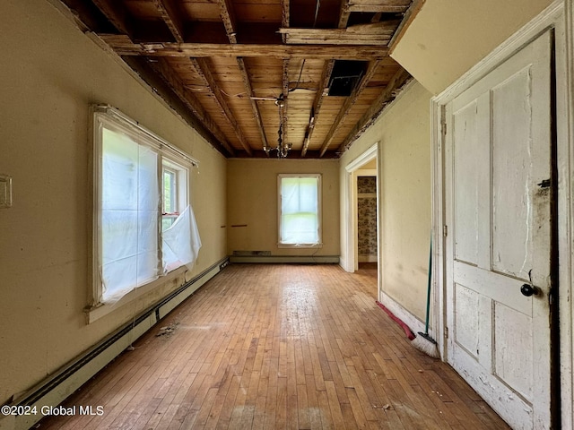 unfurnished room with a healthy amount of sunlight, light hardwood / wood-style floors, and wooden ceiling