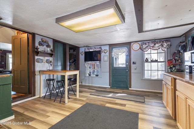 kitchen featuring hardwood / wood-style flooring, a textured ceiling, and light brown cabinets