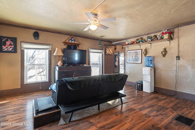 living room featuring dark wood-type flooring and ceiling fan