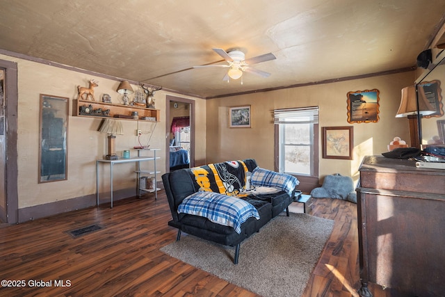 living room featuring crown molding, dark wood-type flooring, and ceiling fan