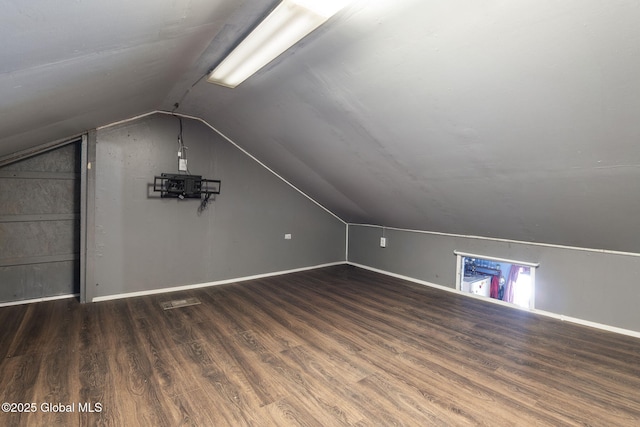 additional living space with hardwood / wood-style floors and vaulted ceiling