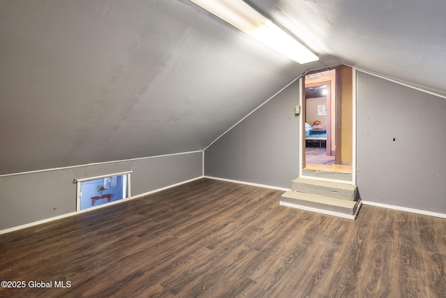 bonus room with lofted ceiling and dark hardwood / wood-style flooring