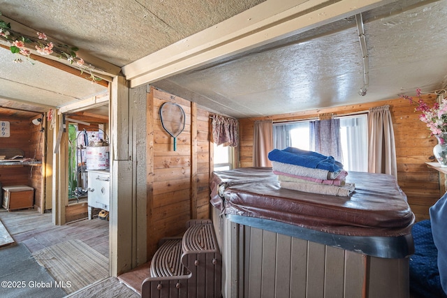 interior space with a textured ceiling and wood walls