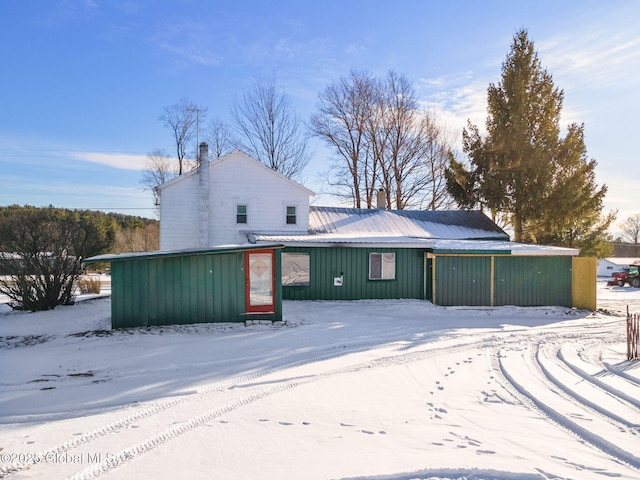 view of snow covered back of property