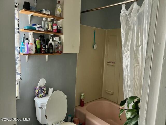 bathroom with shower / bath combo and toilet