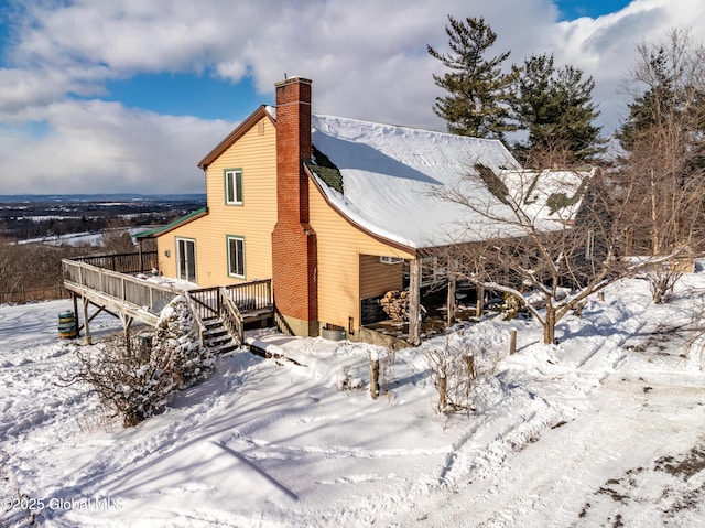 view of snowy exterior featuring a deck