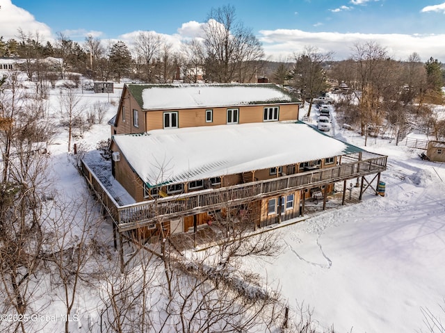 view of snow covered back of property