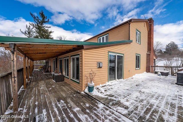 snow covered property with a deck