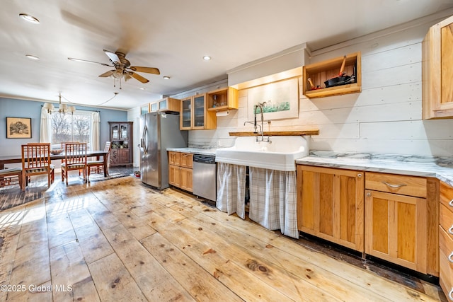 kitchen featuring light hardwood / wood-style flooring, pendant lighting, sink, ceiling fan with notable chandelier, and stainless steel appliances