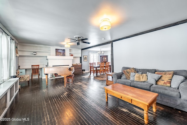 living room featuring ceiling fan with notable chandelier and dark hardwood / wood-style floors