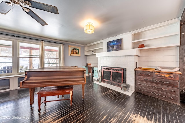 miscellaneous room featuring built in shelves, ornamental molding, dark hardwood / wood-style floors, and a fireplace