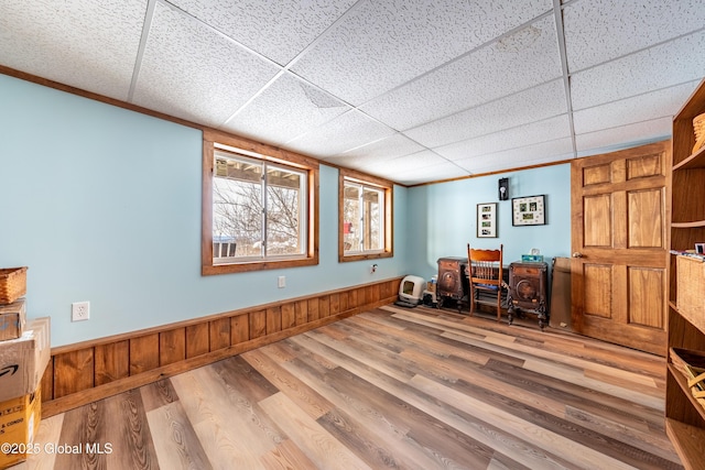 office area with hardwood / wood-style flooring, wooden walls, and a paneled ceiling