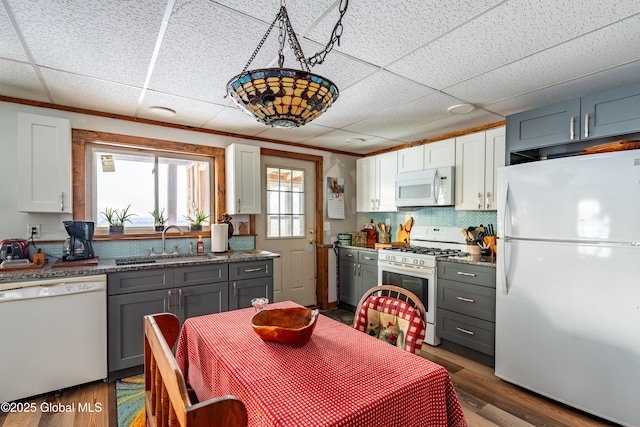 kitchen featuring dark hardwood / wood-style flooring, sink, white cabinetry, gray cabinets, and white appliances