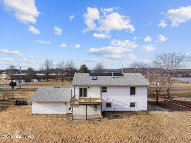 back of property with a lawn and a wooden deck