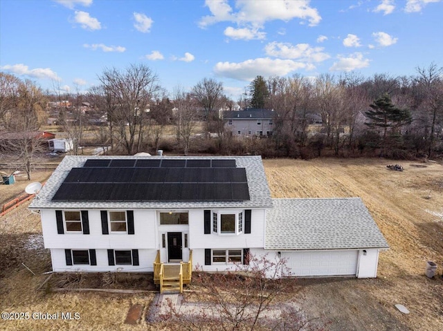 view of front facade featuring a garage and solar panels